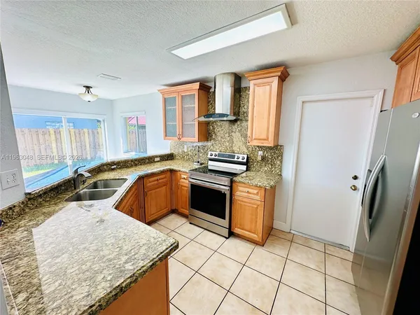 a kitchen with stainless steel appliances granite countertop a stove a sink and a refrigerator