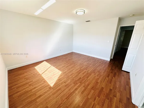 a view of a room with wooden floor