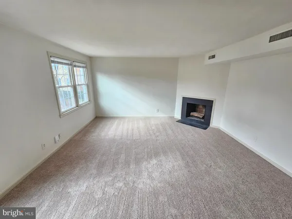 a view of a livingroom with a fireplace and a window