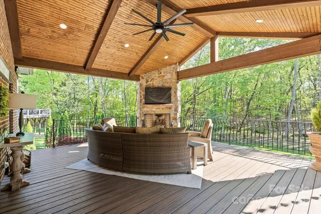 a view of a patio with table and chairs potted plants with wooden floor and fence