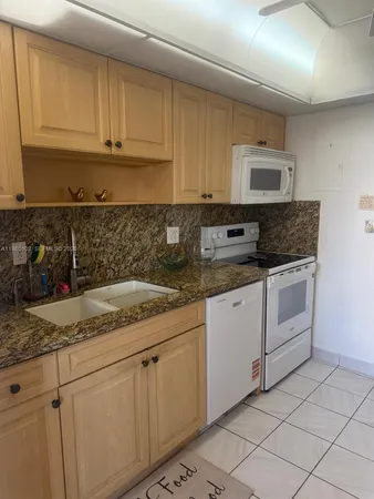 a kitchen with stainless steel appliances granite countertop a refrigerator sink and cabinets