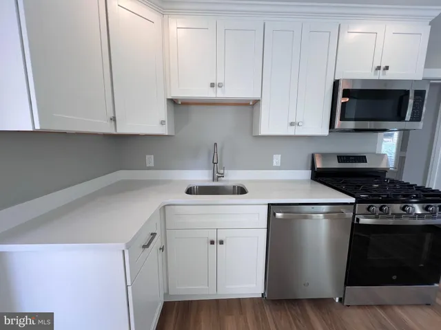 a kitchen with white cabinets and appliances