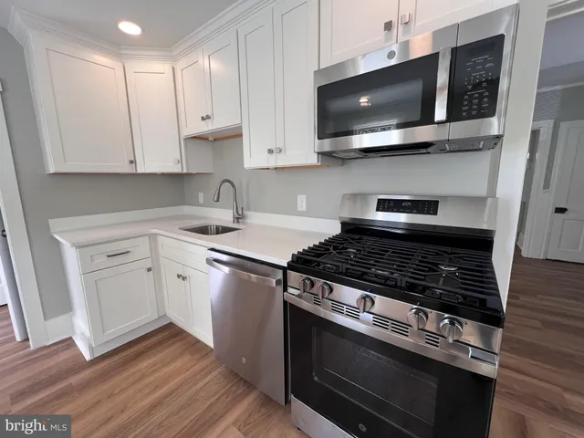 a kitchen with stainless steel appliances a stove a microwave and cabinets