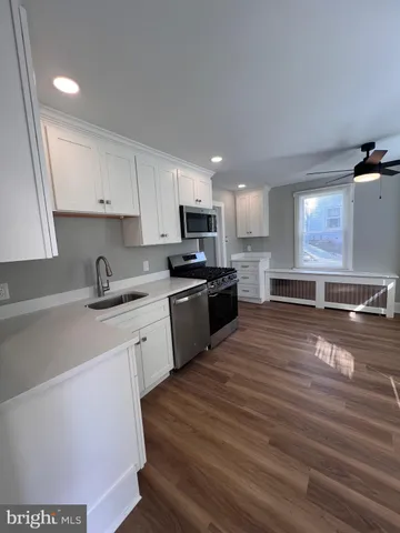 a kitchen with stainless steel appliances granite countertop a sink a stove and a refrigerator