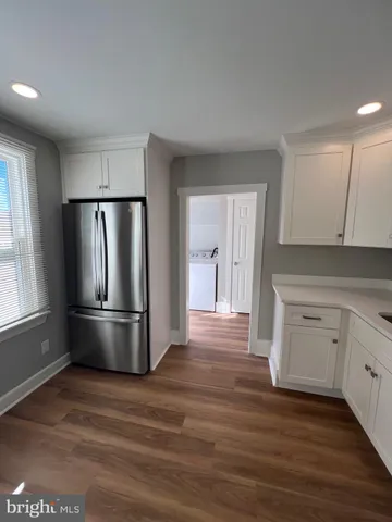 a kitchen with a refrigerator a sink and dishwasher a stove top oven with wooden floor