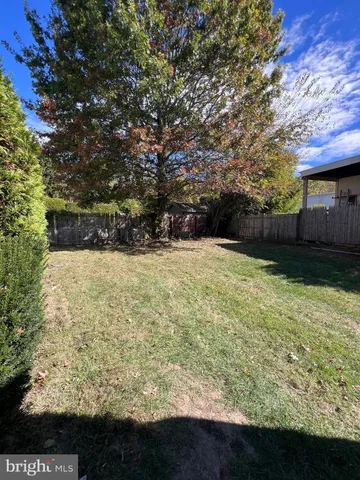 a view of a yard with wooden fence