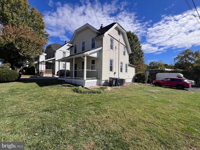 a front view of a house with a garden and trees