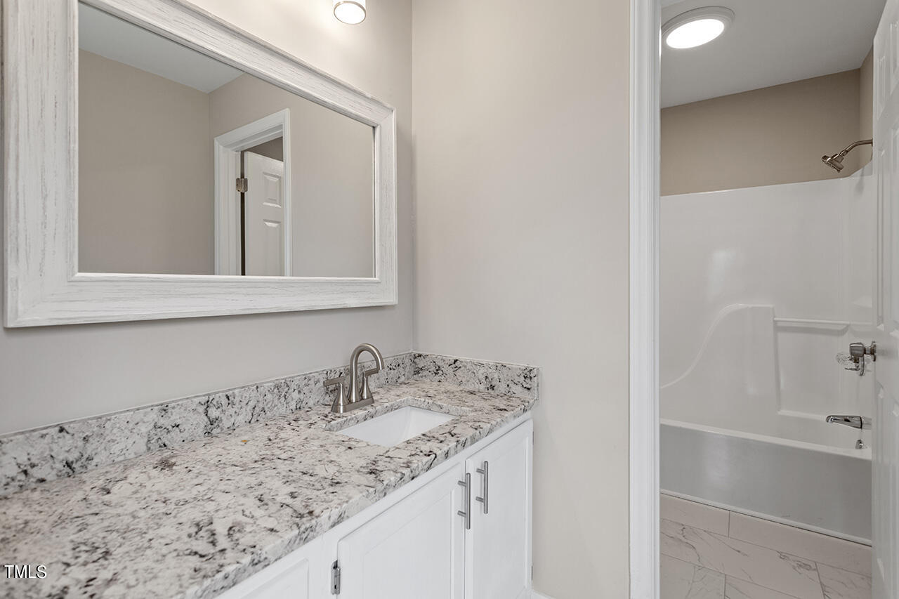 2127 Bainbridge Road Stedman, NC 28391 - Photo 16 of 27 a bathroom with a granite countertop sink and a mirror
