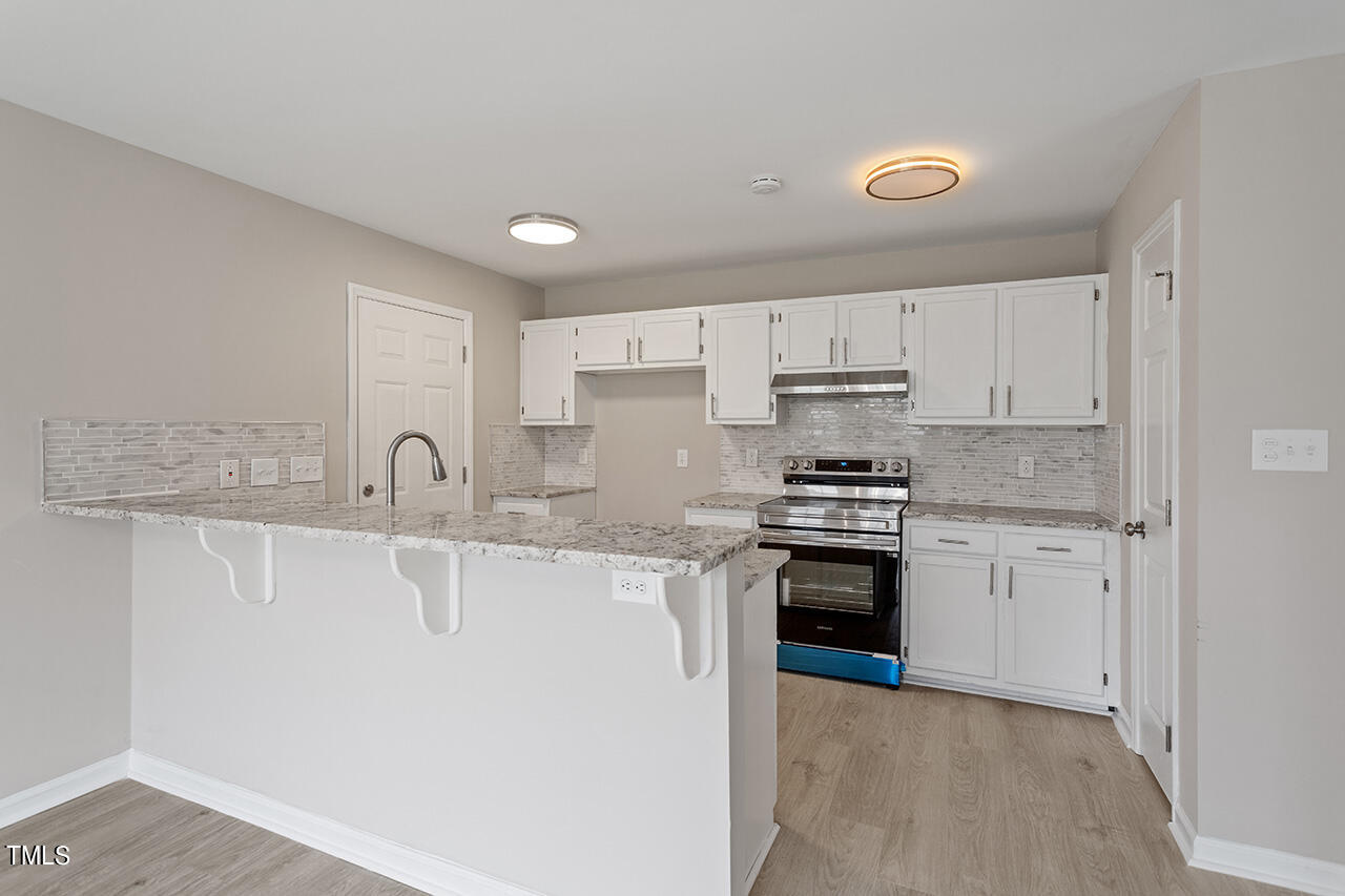 2127 Bainbridge Road Stedman, NC 28391 - Photo 2 of 27 a kitchen with stainless steel appliances granite countertop a sink and cabinets