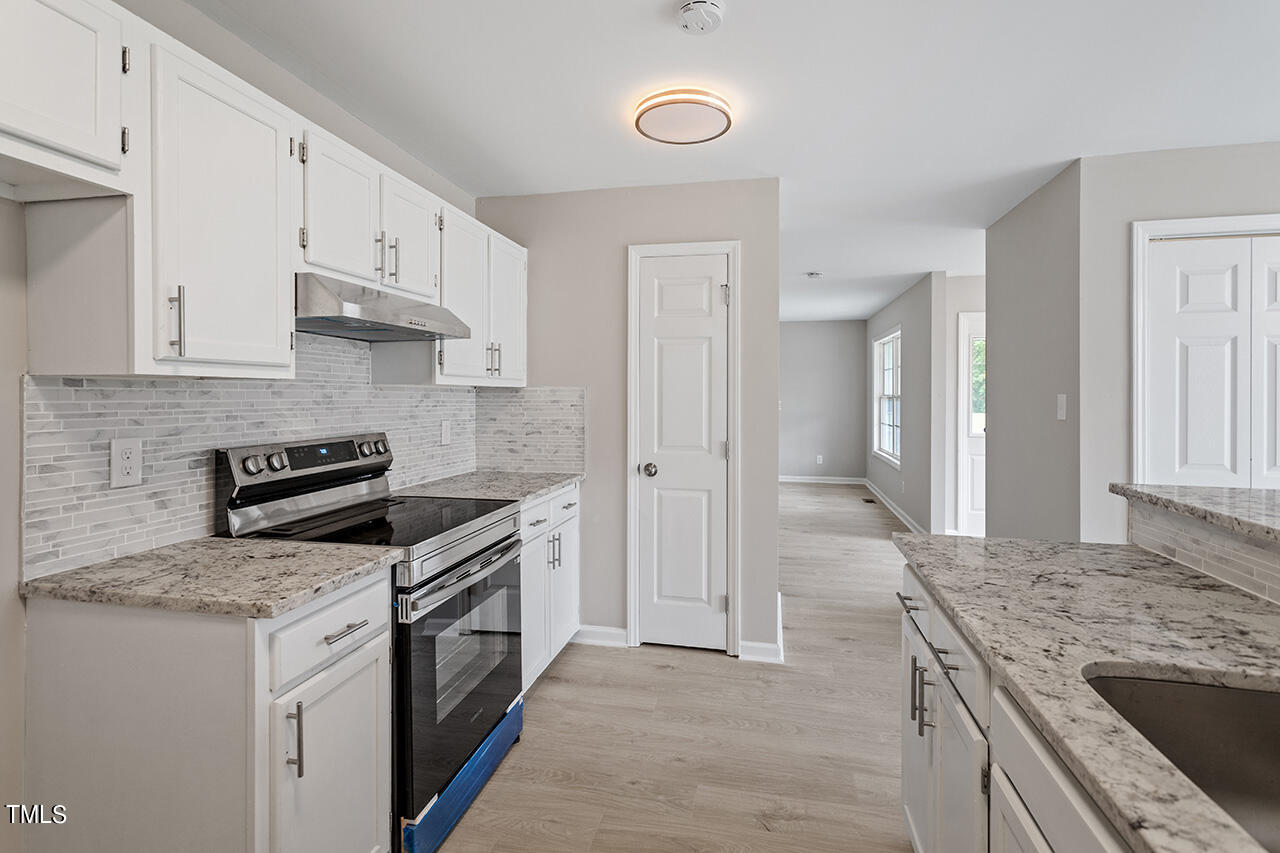 2127 Bainbridge Road Stedman, NC 28391 - Photo 6 of 27 a kitchen with granite countertop a sink stove and refrigerator