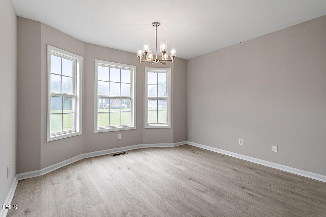 2127 Bainbridge Road Stedman, NC 28391 - Photo 8 of 27 an empty room with wooden floor and windows