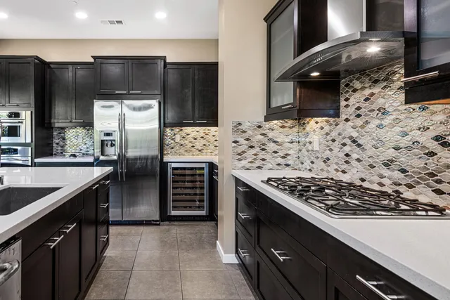 a kitchen with stainless steel appliances kitchen island granite countertop a stove and a refrigerator