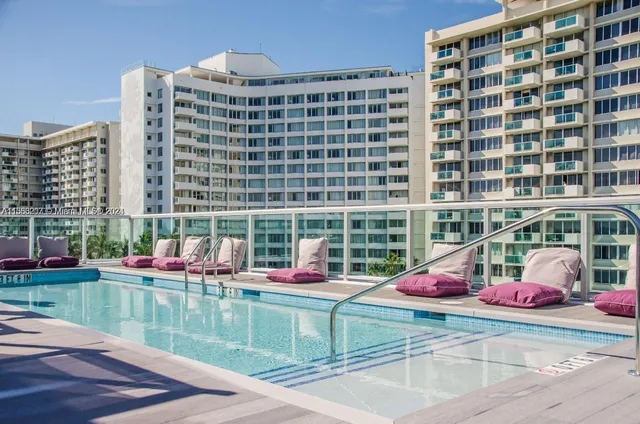 a front view of a building with swimming pool and outdoor seating