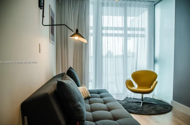 a living room with furniture and a floor to ceiling window