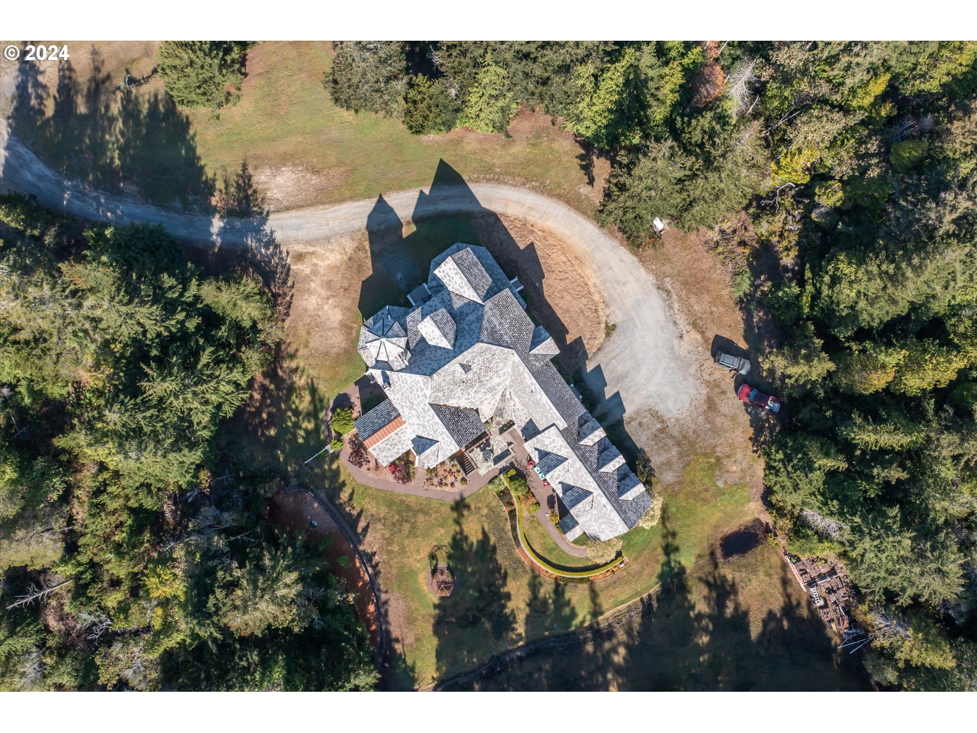 54980 Morrison Road Bandon, OR 97411 - Photo 2 of 48 an aerial view of a house with outdoor space and a lake view