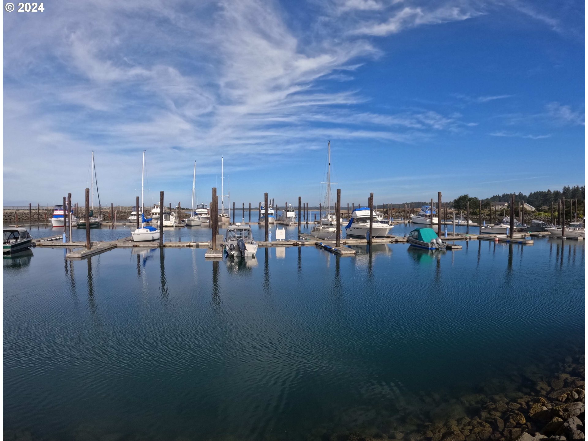 54980 Morrison Road Bandon, OR 97411 - Photo 47 of 48 a view of water with boats and trees in the background