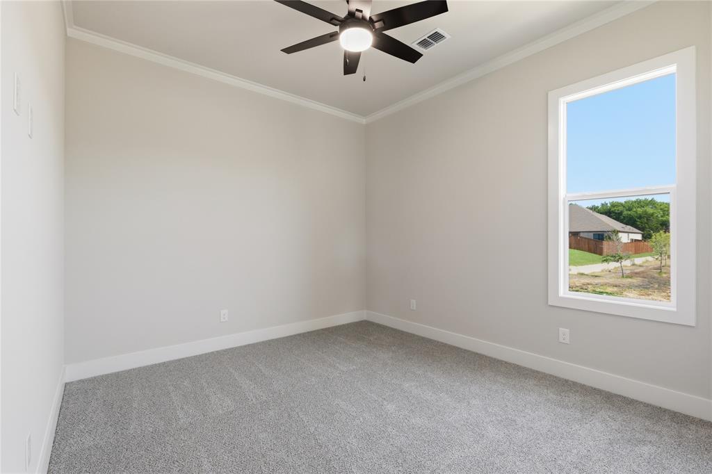 713 Anne Road Van Alstyne, TX 75495 - Photo 17 of 29 Room featuring neutral wall tones, gray carpeting, a single window with white trim, a ceiling fan with light fixture, and white baseboards