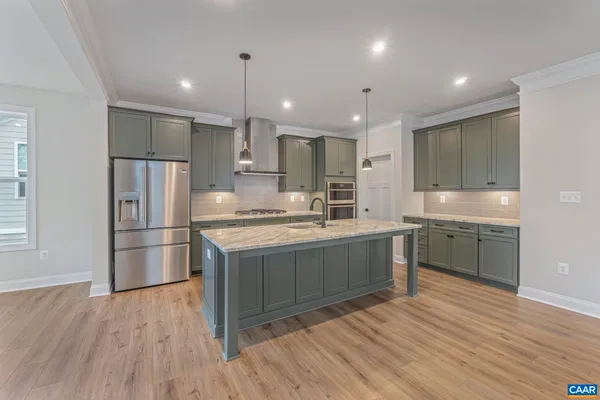 a kitchen with stainless steel appliances granite countertop a refrigerator a sink dishwasher a stove and a refrigerator with wooden floor