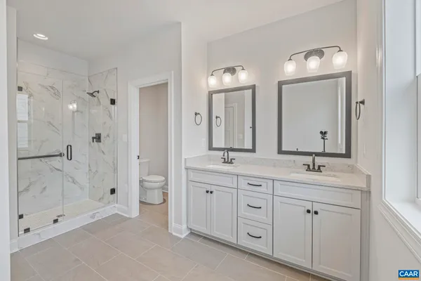 a spacious bathroom with a double vanity sink mirror double and shower