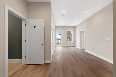 a view of empty room with wooden floor