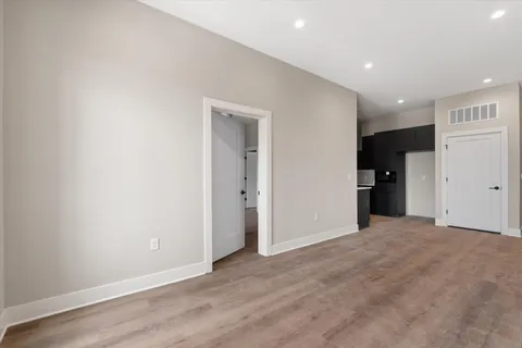 a view of an empty room with wooden floor