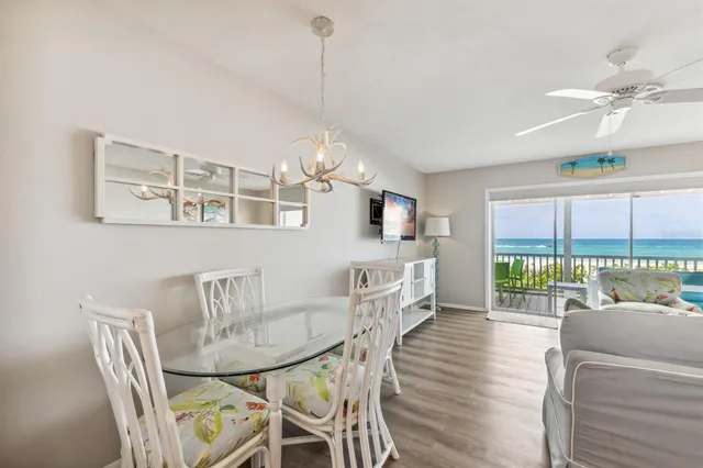 a view of a dining room with furniture a chandelier and wooden floor