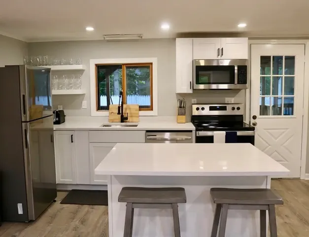 a kitchen with stainless steel appliances a stove sink microwave and refrigerator