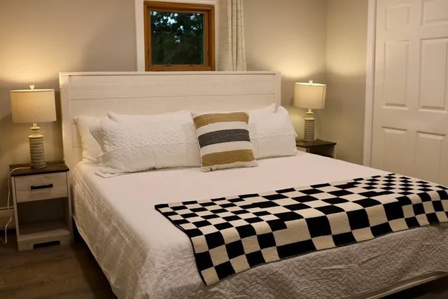 a bedroom with a bed and wooden floor