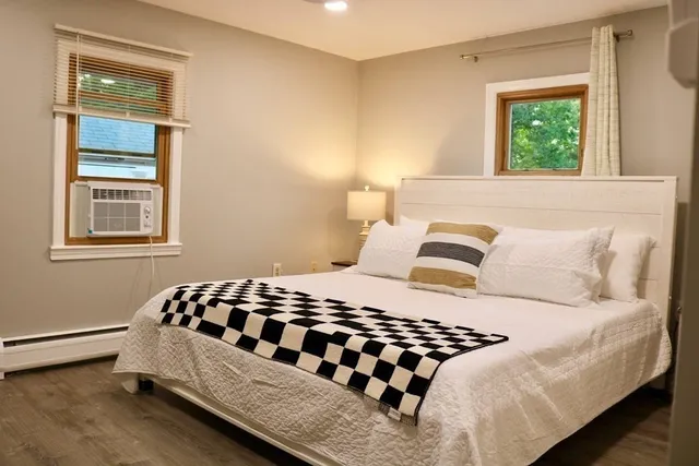 a bedroom with a bed and wooden floor