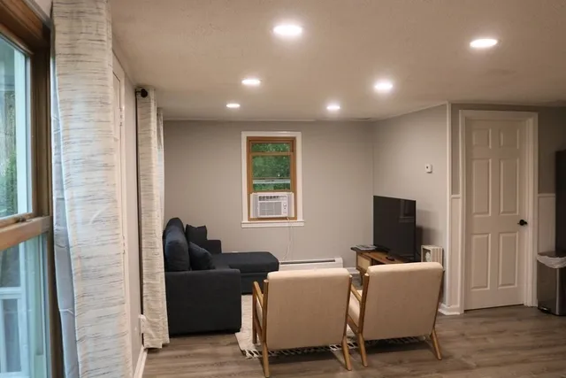 a living room with furniture a flat screen tv and a fireplace