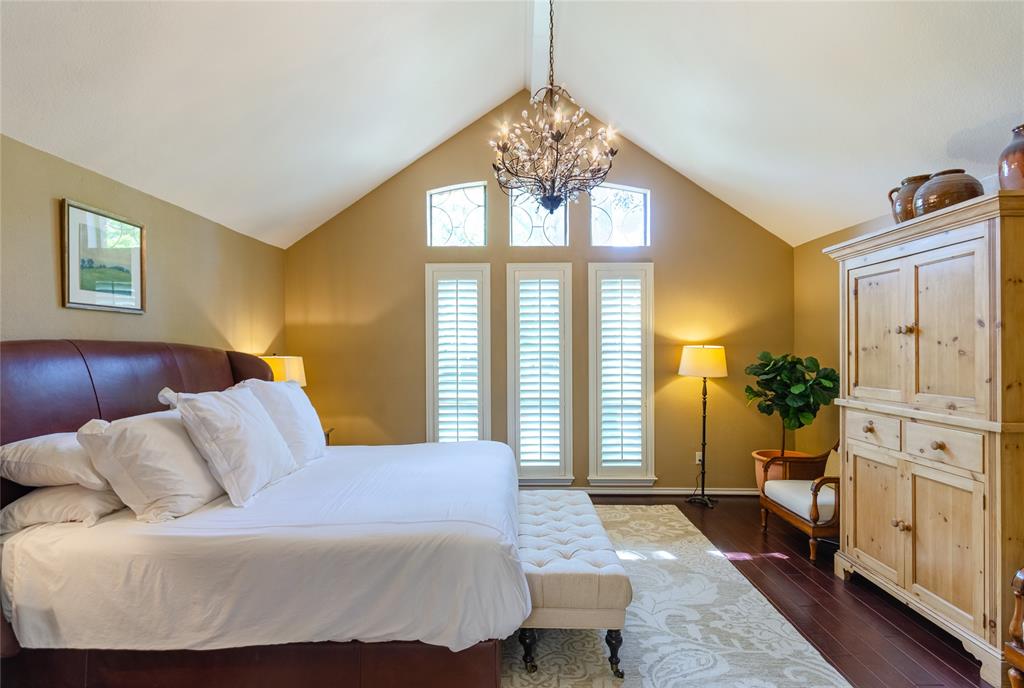 2605 Rothland Lane Plano, TX 75023 - Photo 17 of 40 a bedroom with a large bed and a chandelier