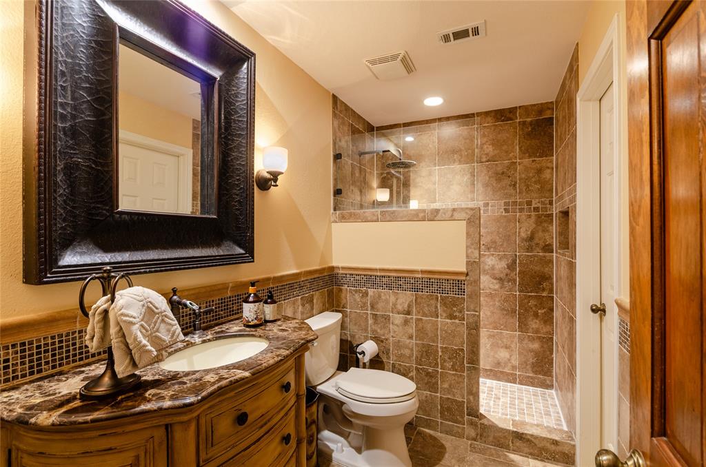 2605 Rothland Lane Plano, TX 75023 - Photo 33 of 40 a bathroom with a granite countertop sink mirror vanity and toilet