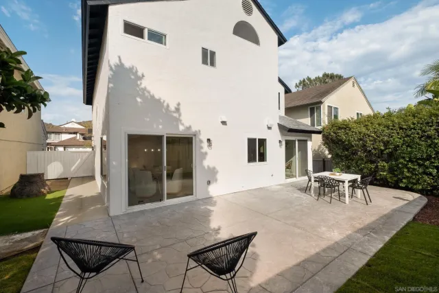 a view of backyard with a table and chairs and potted plants