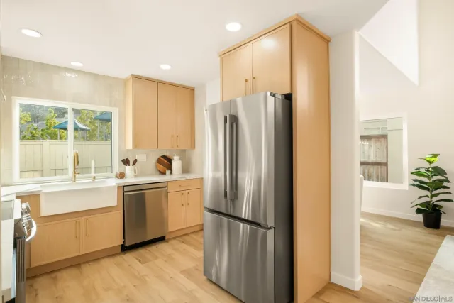 a kitchen with stainless steel appliances granite countertop a refrigerator and a sink