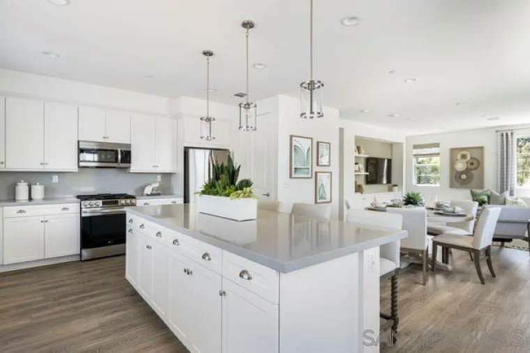 2220 South Ava Glen, Unit 906 Escondido, CA 92025 - Photo 14 of 23 a kitchen with stainless steel appliances kitchen island granite countertop a stove a sink a dining table and chairs with wooden floor