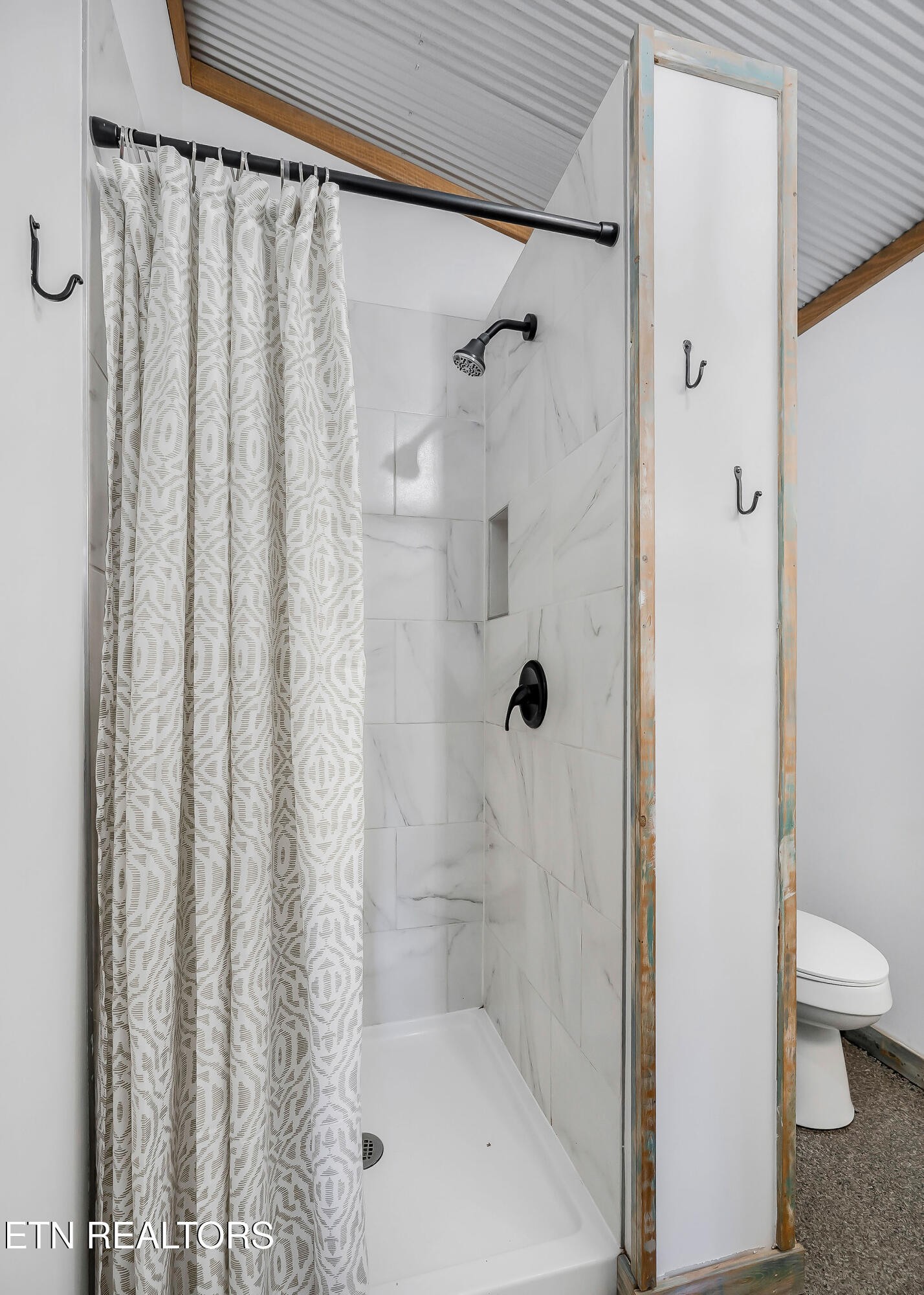 3247 Moodyville Road Byrdstown, TN 38549 - Photo 12 of 27 a bathroom with a shower curtain and a toilet