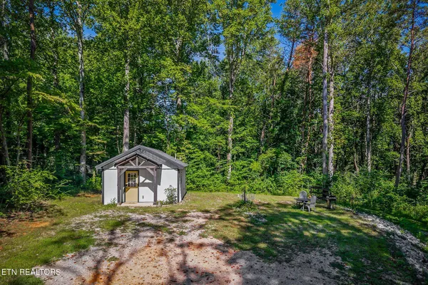 a front view of a house with a yard and trees