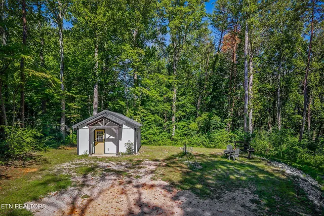 a front view of a house with a yard and trees