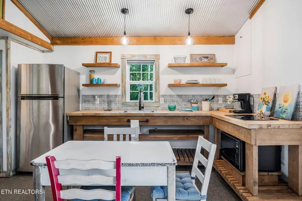 a kitchen with a table chairs refrigerator and microwave