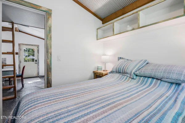 a bedroom with a bed and table chair