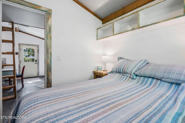 a bedroom with a bed and table chair