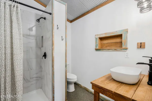 a bathroom with a granite countertop sink a toilet and shower