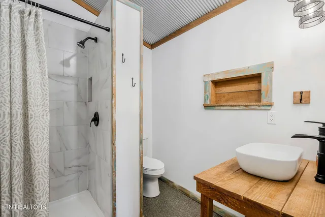 a bathroom with a granite countertop sink a toilet and shower