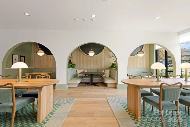 a living room with a table chairs and a clock