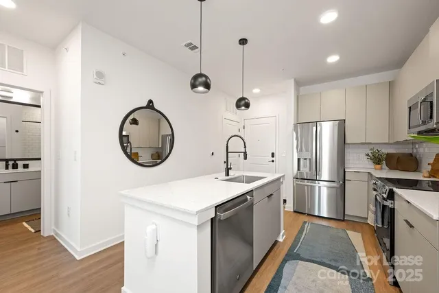 a kitchen with stainless steel appliances granite countertop a sink a stove and refrigerator
