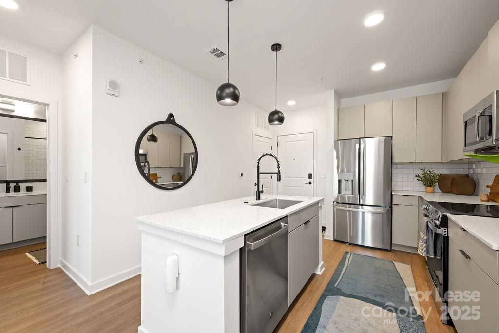 4101 Raleigh Street, Unit S2 Charlotte, NC 28206 - Photo 37 of 48 a kitchen with stainless steel appliances granite countertop a sink a stove a refrigerator and island
