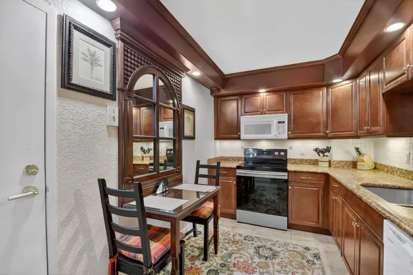 a kitchen with a stove a sink and chairs