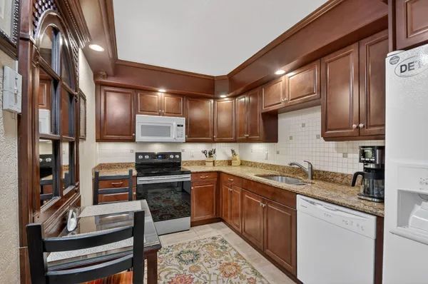 a kitchen with stainless steel appliances granite countertop a stove sink and cabinets