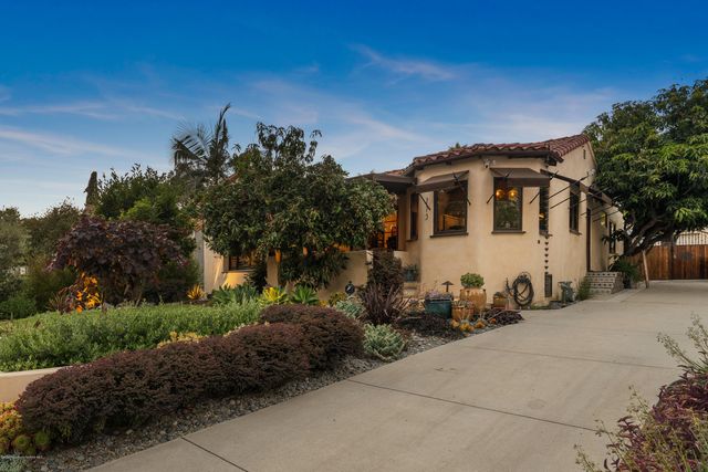 a front view of a house with trees around