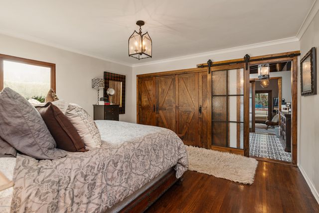 a bedroom with a large bed and a chandelier